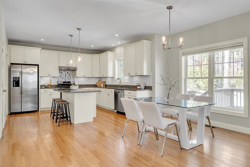 49 Quarry Road, Unit 49 Acton, MA 01720 - Photo 10 of 42 a kitchen with stainless steel appliances kitchen island granite countertop a dining table chairs refrigerator and sink