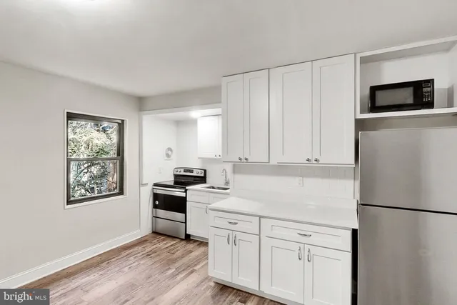 a kitchen with white cabinets and white appliances