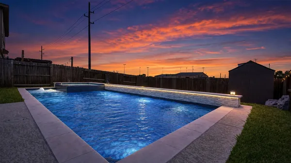 a view of a house with a swimming pool and a yard