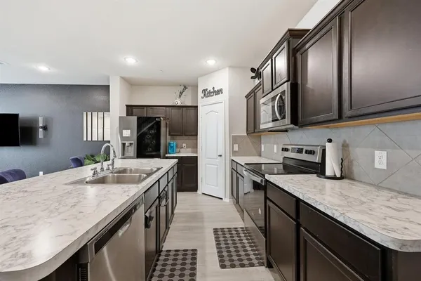 a kitchen with stainless steel appliances granite countertop a sink stove and refrigerator
