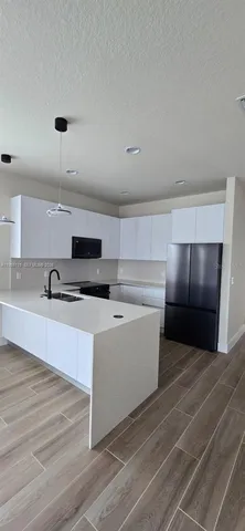 a view of kitchen with microwave cabinets and refrigerator