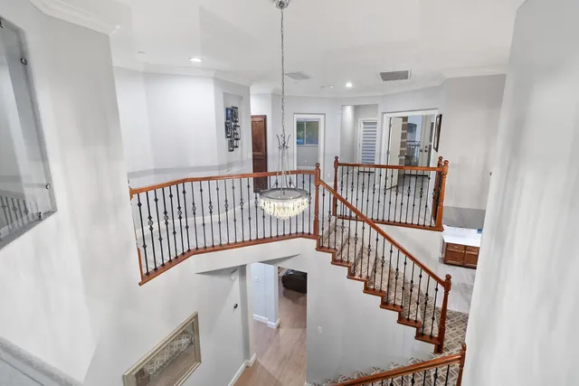 a view of staircase with railing and white walls