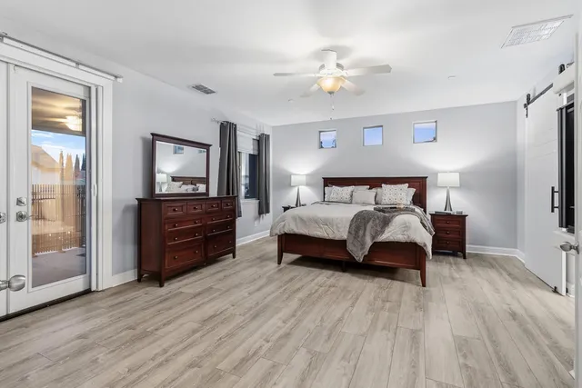 a spacious bedroom with a bed and a flat screen tv