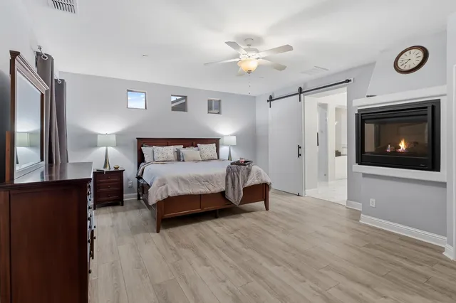 a bedroom with a bed and a flat tv screen on dresser