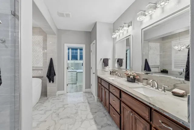 a bathroom with a tub sink shower and mirror