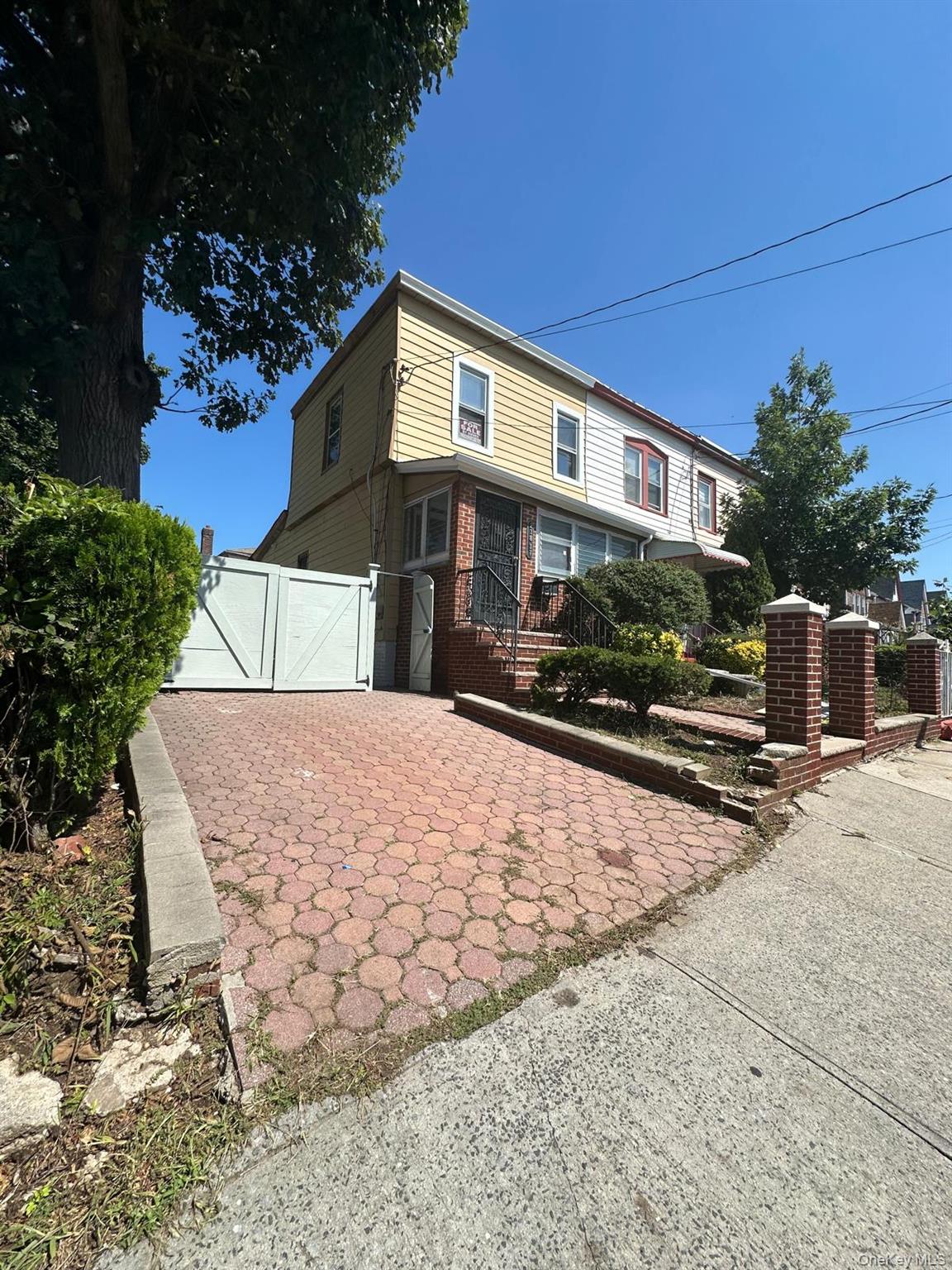 218-17 109th Avenue Queens, NY 11429 - Photo 15 of 35 View of front of house with a gate, a garage, and brick siding