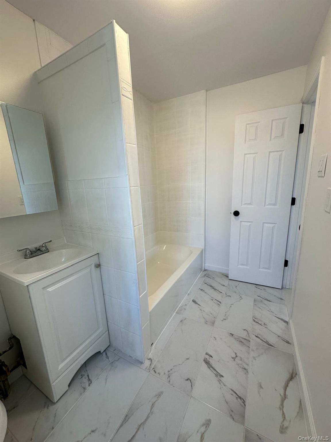 218-17 109th Avenue Queens, NY 11429 - Photo 33 of 35 Full bathroom with vanity, light marble finish flooring, and bathing tub / shower combination