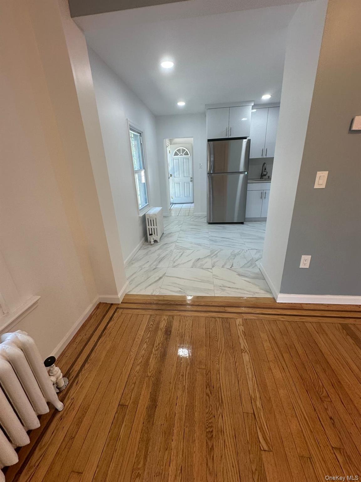 218-17 109th Avenue Queens, NY 11429 - Photo 8 of 35 Hall with radiator, light wood-style floors, and recessed lighting