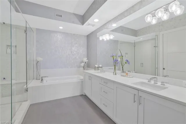 a bathroom with a tub shower vanity and a sink