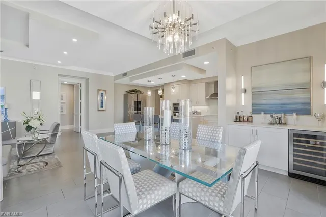 a dining room with furniture a chandelier and kitchen view