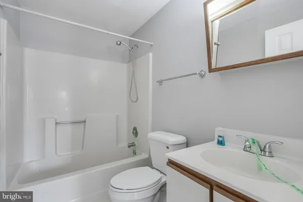 a white toilet sitting next to a bath tub