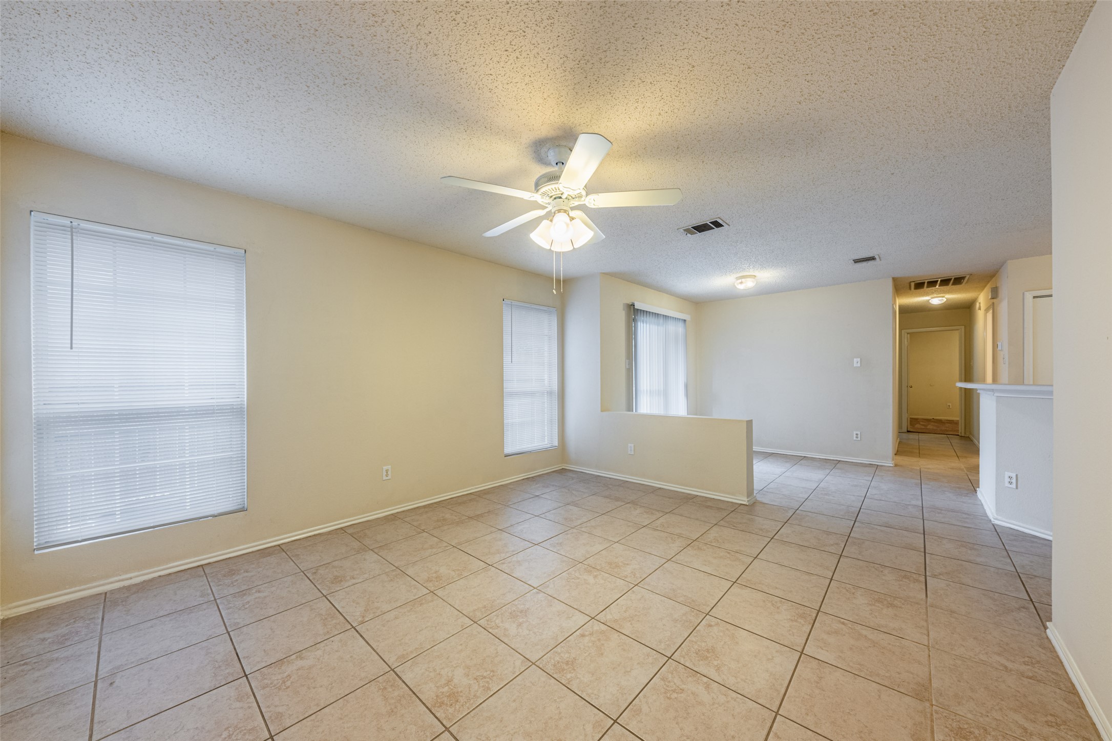 7216 Aldea Drive, Unit A Austin, TX 78745 - Photo 6 of 25 Spacious living area featuring large format tile flooring and a ceiling fan with integrated lighting