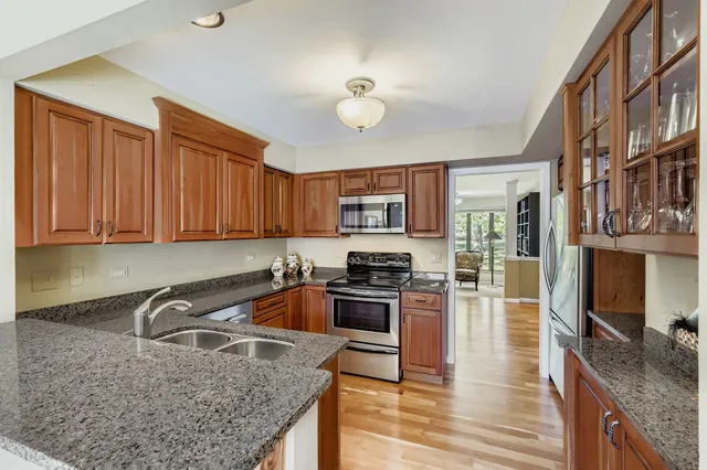a kitchen with stainless steel appliances granite countertop a sink stove and refrigerator