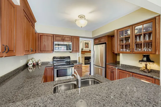a kitchen with stainless steel appliances granite countertop a refrigerator stove and sink