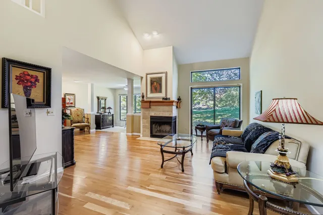 a living room with furniture a fireplace and a large window