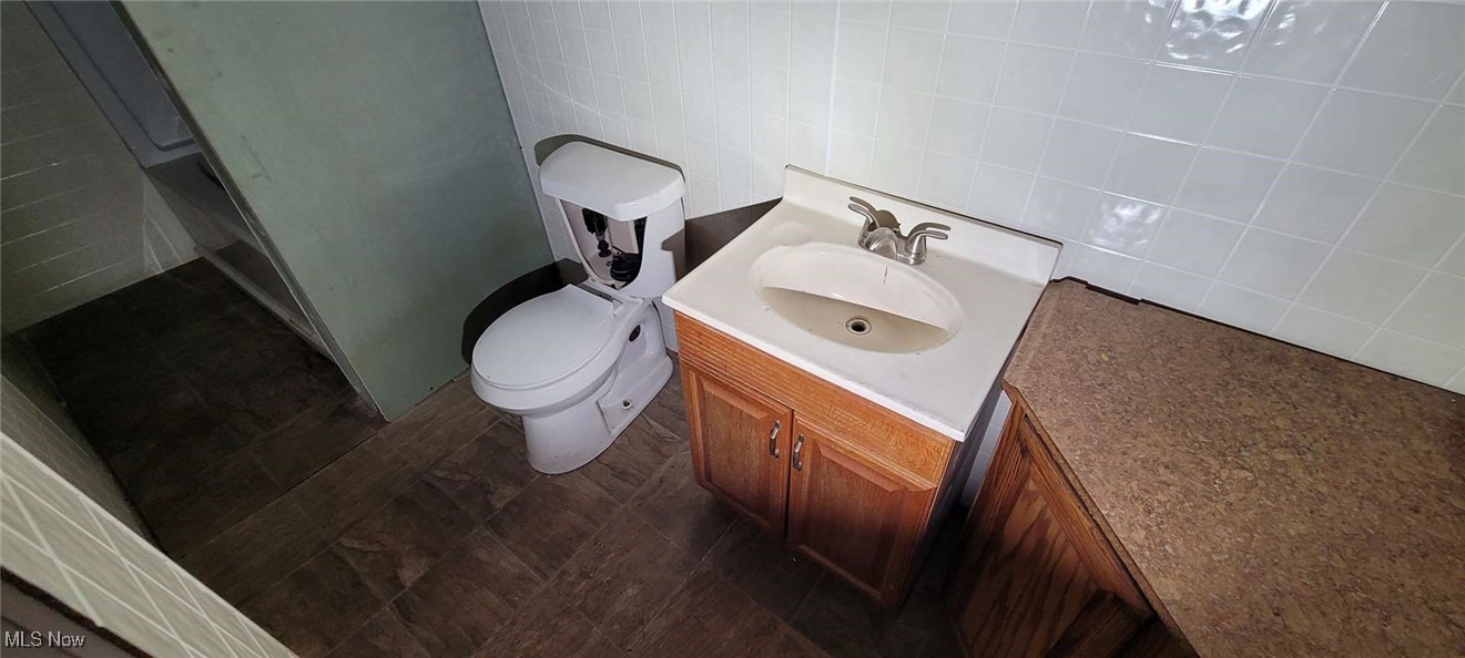 6816 Rathbun Avenue Cleveland, OH 44105 - Photo 10 of 10 Bathroom featuring vanity, toilet, and tile walls