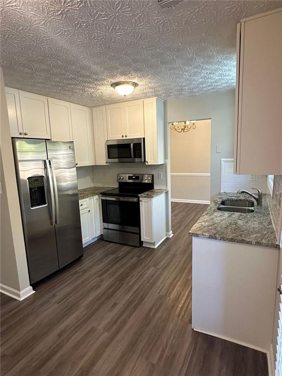 3993 Paloverde Drive Kennesaw, GA 30144 - Photo 5 of 25 a kitchen with kitchen island granite countertop a sink cabinets and stainless steel appliances