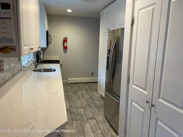 a kitchen with granite countertop white cabinets and white appliances
