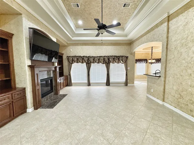 a view of an empty room with a fireplace and a window