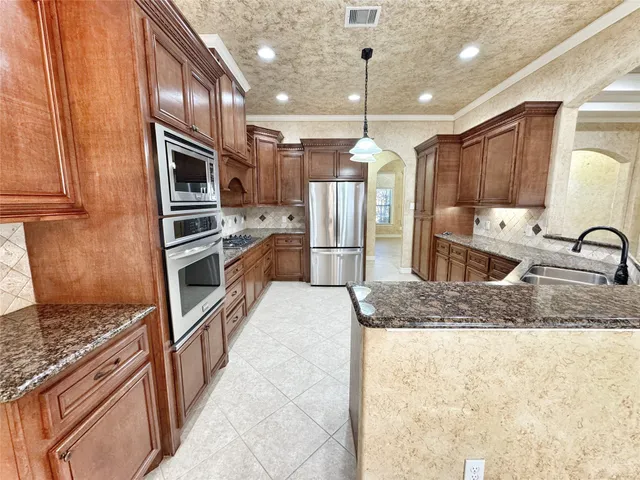 a kitchen with stainless steel appliances granite countertop a refrigerator and a sink