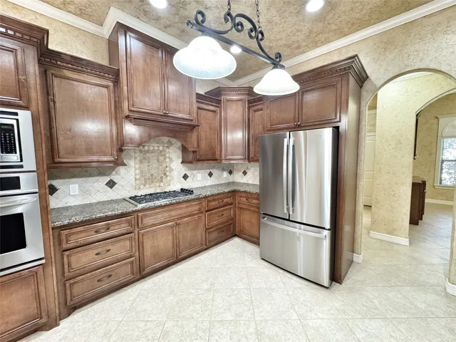 a kitchen with stainless steel appliances granite countertop a refrigerator and a sink