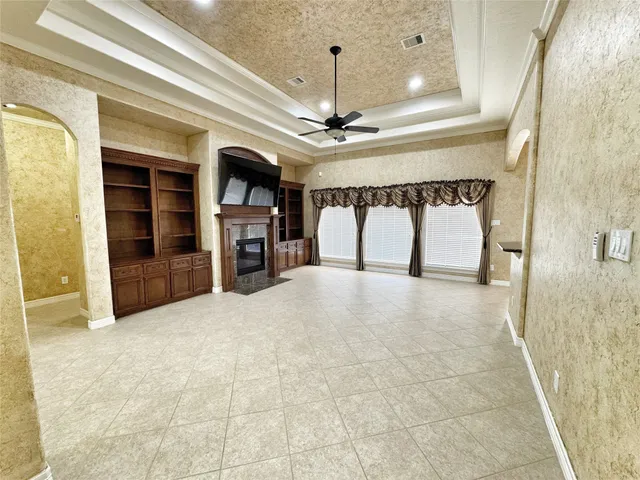 a view of empty room with a fireplace and chandelier