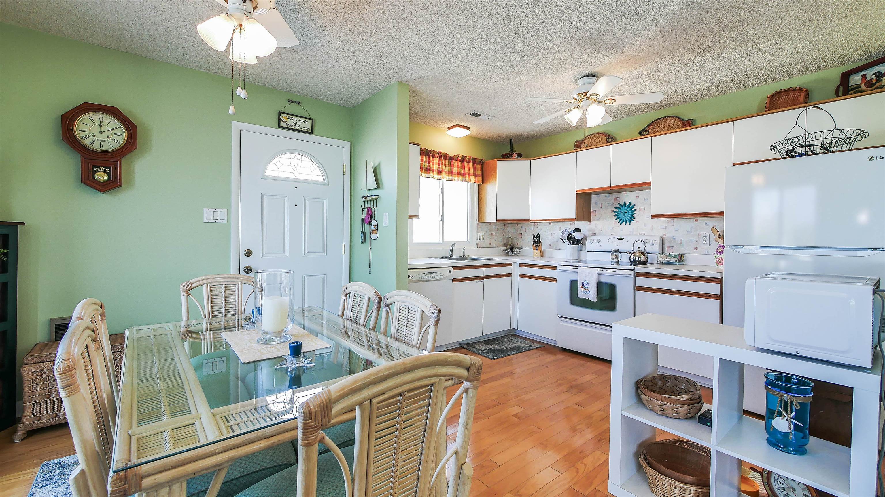 4025 4th, Unit TOP Avalon, NJ 08202 - Photo 31 of 32 a kitchen with stainless steel appliances granite countertop a sink dishwasher a refrigerator and a dining table with white cabinets