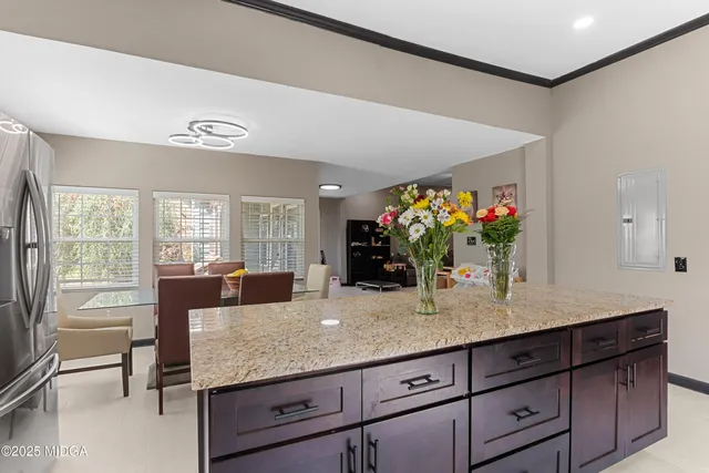a dining hall with granite countertop a coffee maker on granite counter tops and a view of living room