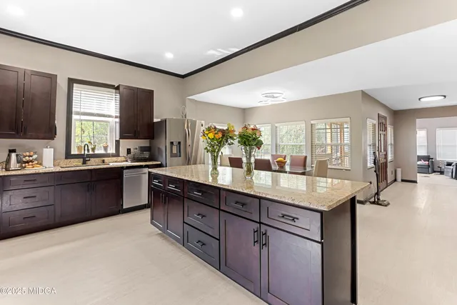 a kitchen with stainless steel appliances granite countertop a sink counter space cabinets and a large window