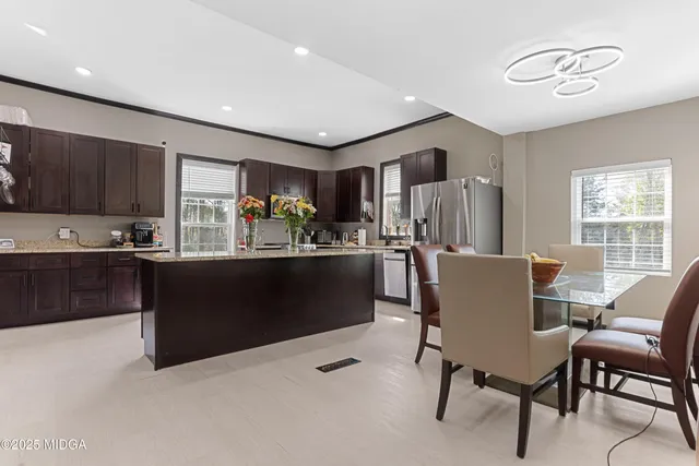 a kitchen with granite countertop a refrigerator and a dining table