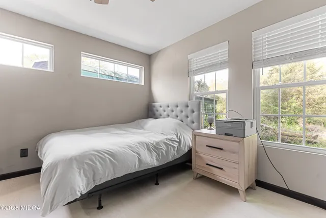 a bedroom with a bed and a large window