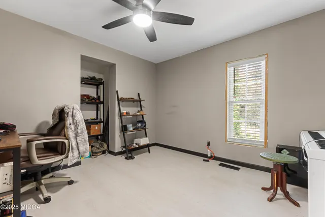 a view of a workspace with furniture and a window