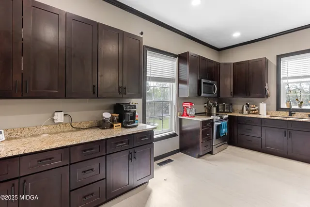 a kitchen with a refrigerator stove top oven sink and cabinets