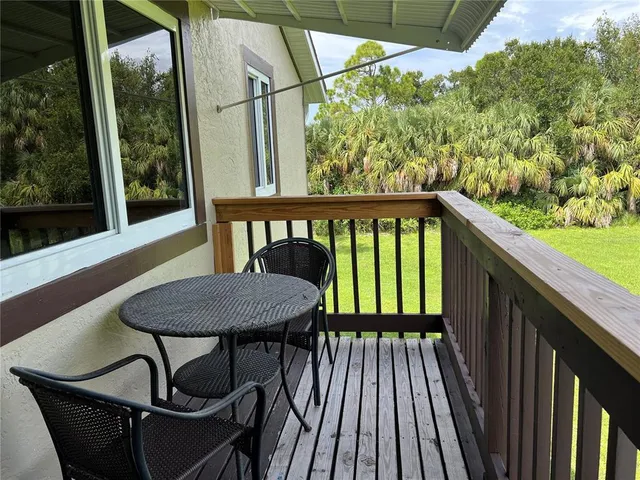 a view of a balcony with chairs and wooden floor