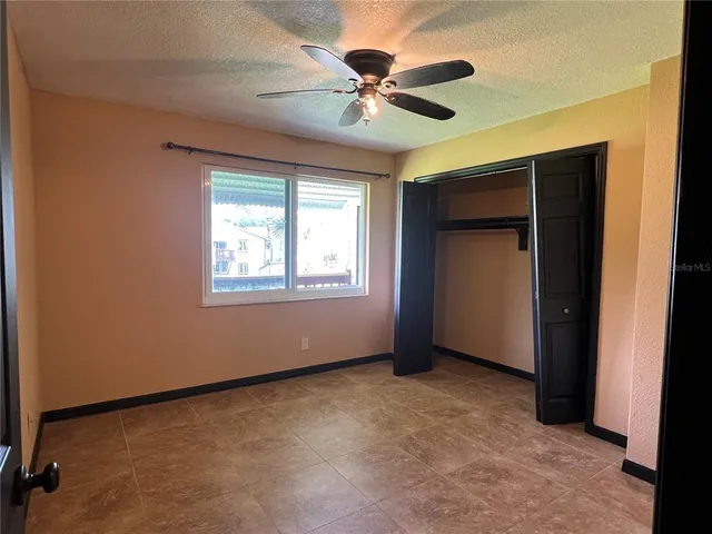 an empty room with windows and fan