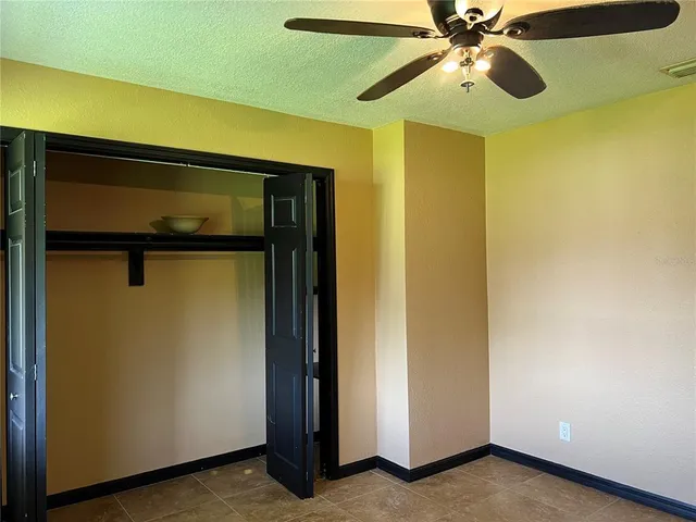a view of a room with a ceiling fan and a fan
