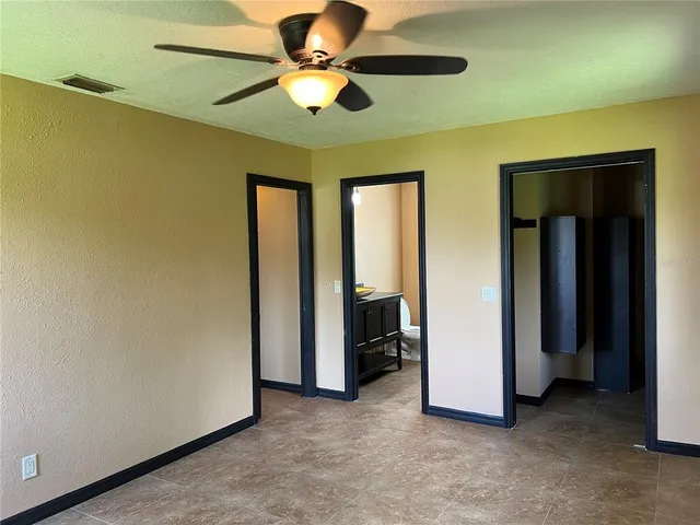 an empty room and chandelier fan