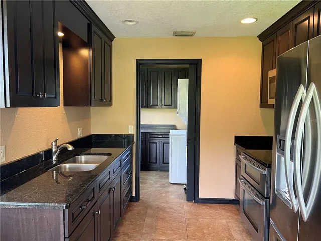a kitchen that has a sink cabinets counter space and stainless steel appliances