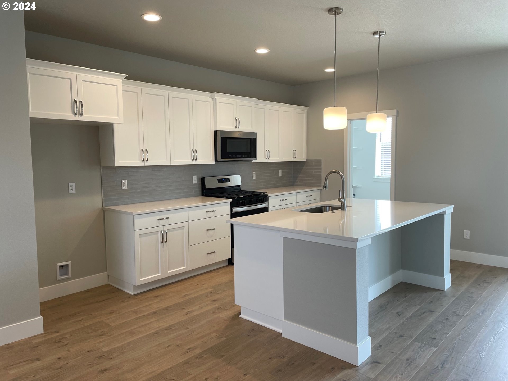 20735 Southwest Boyd Court, Unit 10 Beaverton, OR 97003 - Photo 4 of 47 a kitchen with kitchen island white cabinets and stainless steel appliances