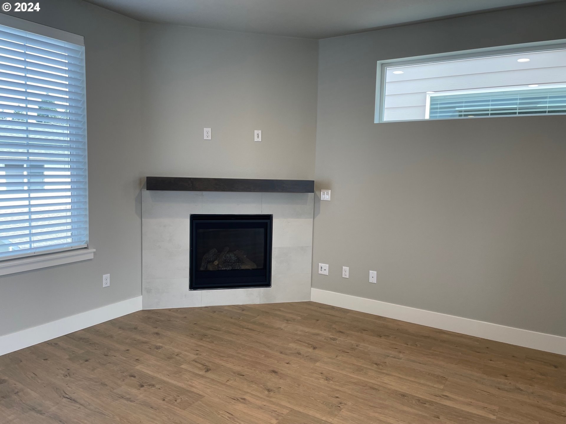 20735 Southwest Boyd Court, Unit 10 Beaverton, OR 97003 - Photo 9 of 47 an empty room with a fireplace and wooden floor