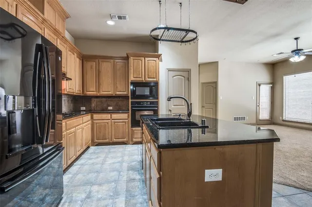 a kitchen with kitchen island granite countertop a sink appliances cabinets and counter space