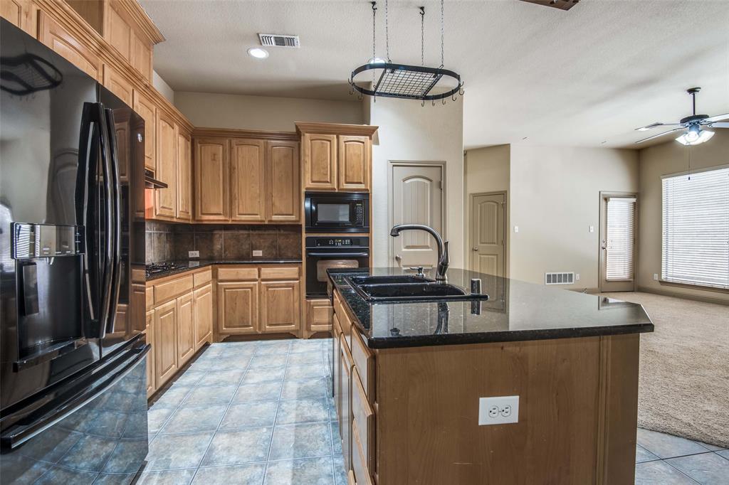 6781 Camino Rio Irving, TX 75039 - Photo 12 of 25 a kitchen with stainless steel appliances granite countertop a sink a stove and refrigerator