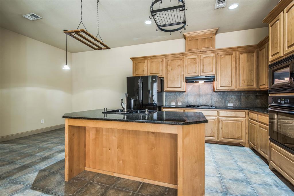 6781 Camino Rio Irving, TX 75039 - Photo 13 of 25 a kitchen with kitchen island granite countertop a sink appliances cabinets and counter space