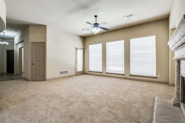 an empty room with windows and fireplace