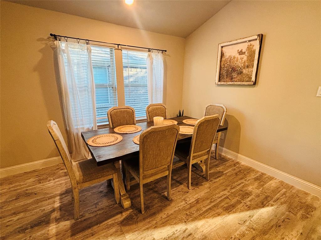 6820 Elm Street Rowlett, TX 75089 - Photo 7 of 12 a view of a dining room with furniture and wooden floor