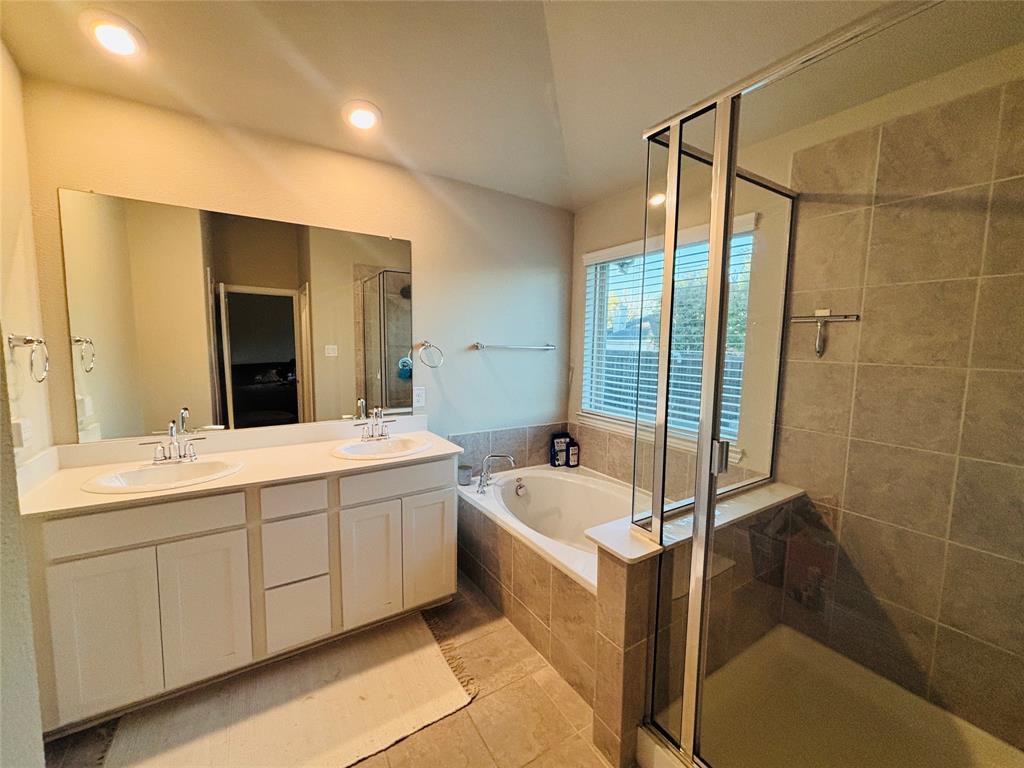 6820 Elm Street Rowlett, TX 75089 - Photo 10 of 12 a spacious bathroom with a tub sink and mirror