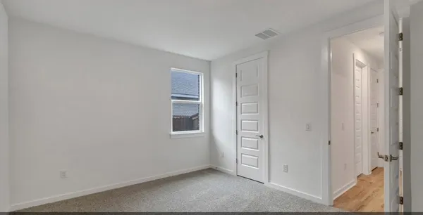 an empty room with closet and a ceiling fan