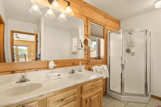 a bathroom with a granite countertop sink a mirror and a shower