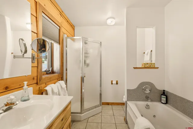 a bathroom with a tub sink and mirror