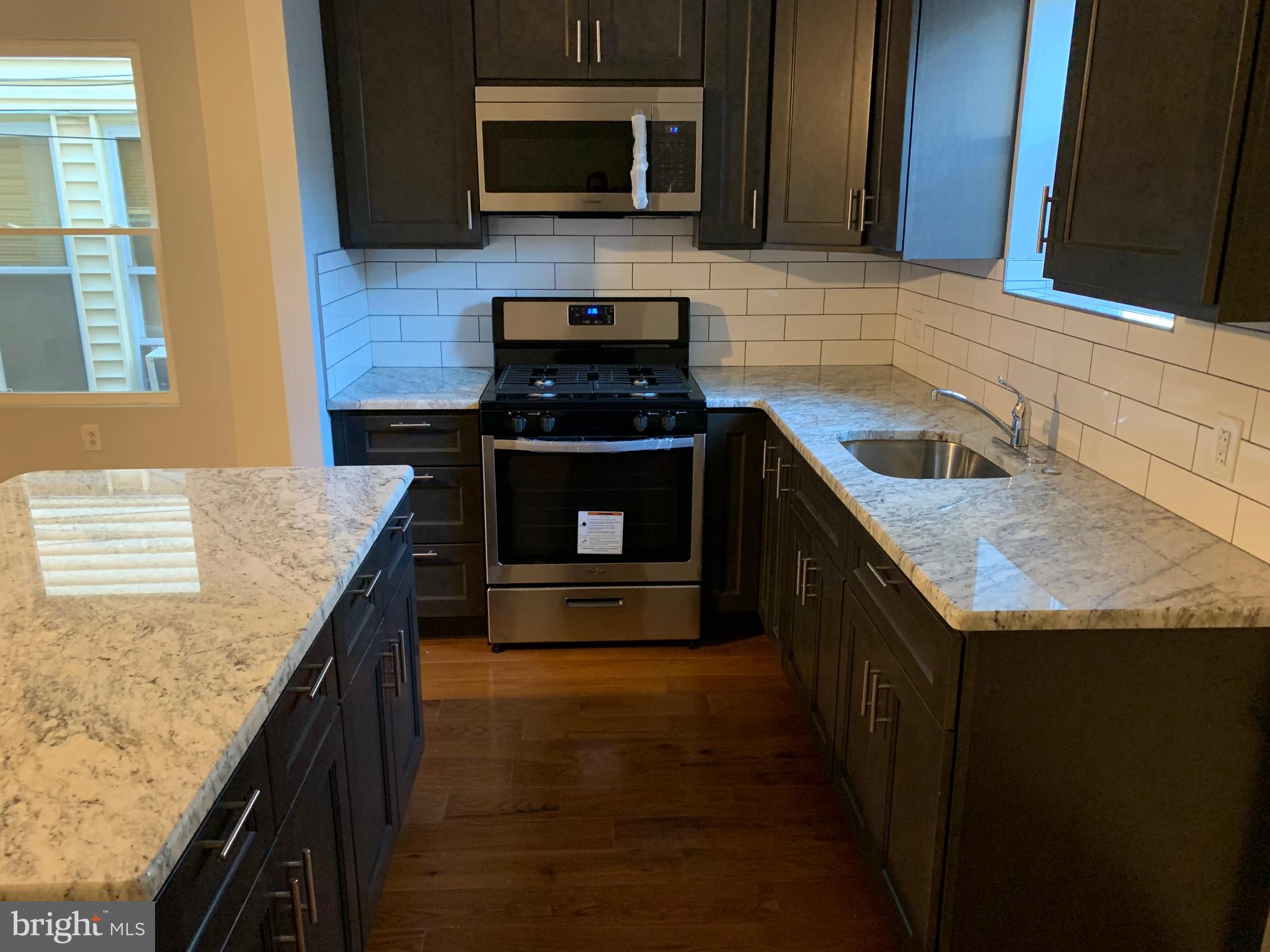 5435 Angora Terrace Philadelphia, PA 19143 - Photo 5 of 7 a kitchen with granite countertop stainless steel appliances and wooden cabinets